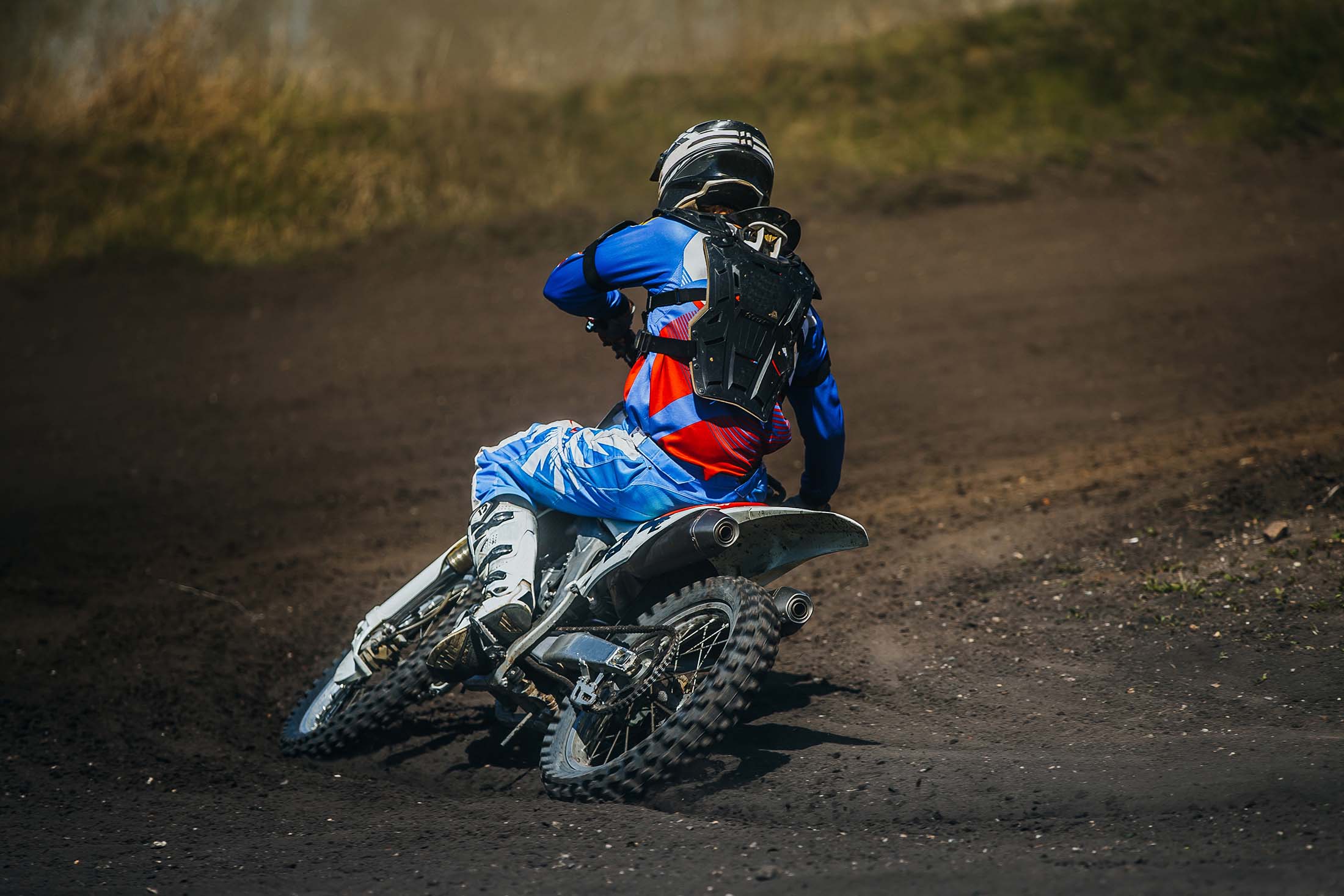 motorcycle racer on a motorcycle rides in turn a dusty track during competition racing